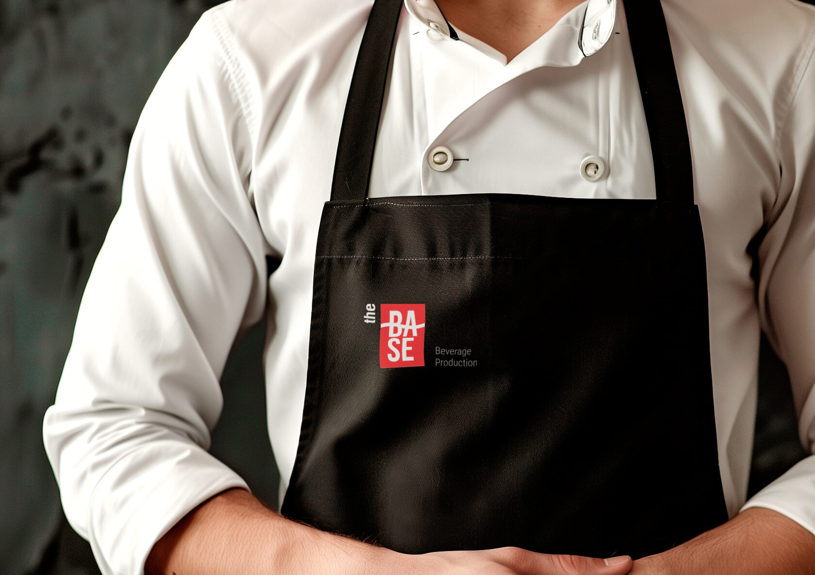 Barista in a THE BASE apron at the bar