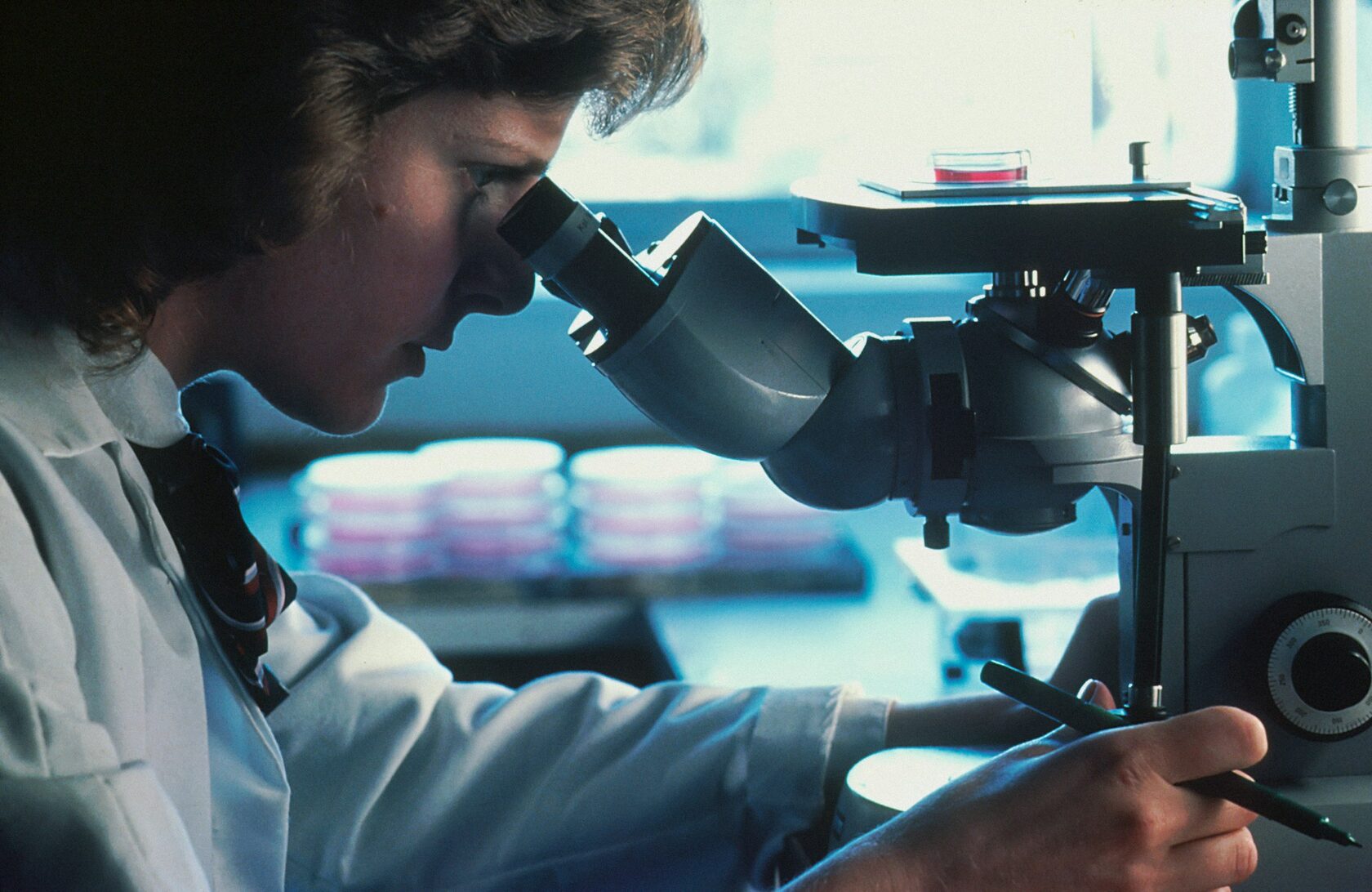 Technician at a microscope in THE BASE laboratory