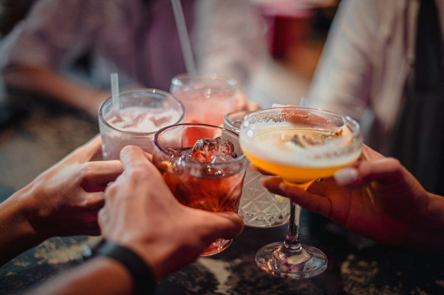 Four mixed drinks raised in a toast